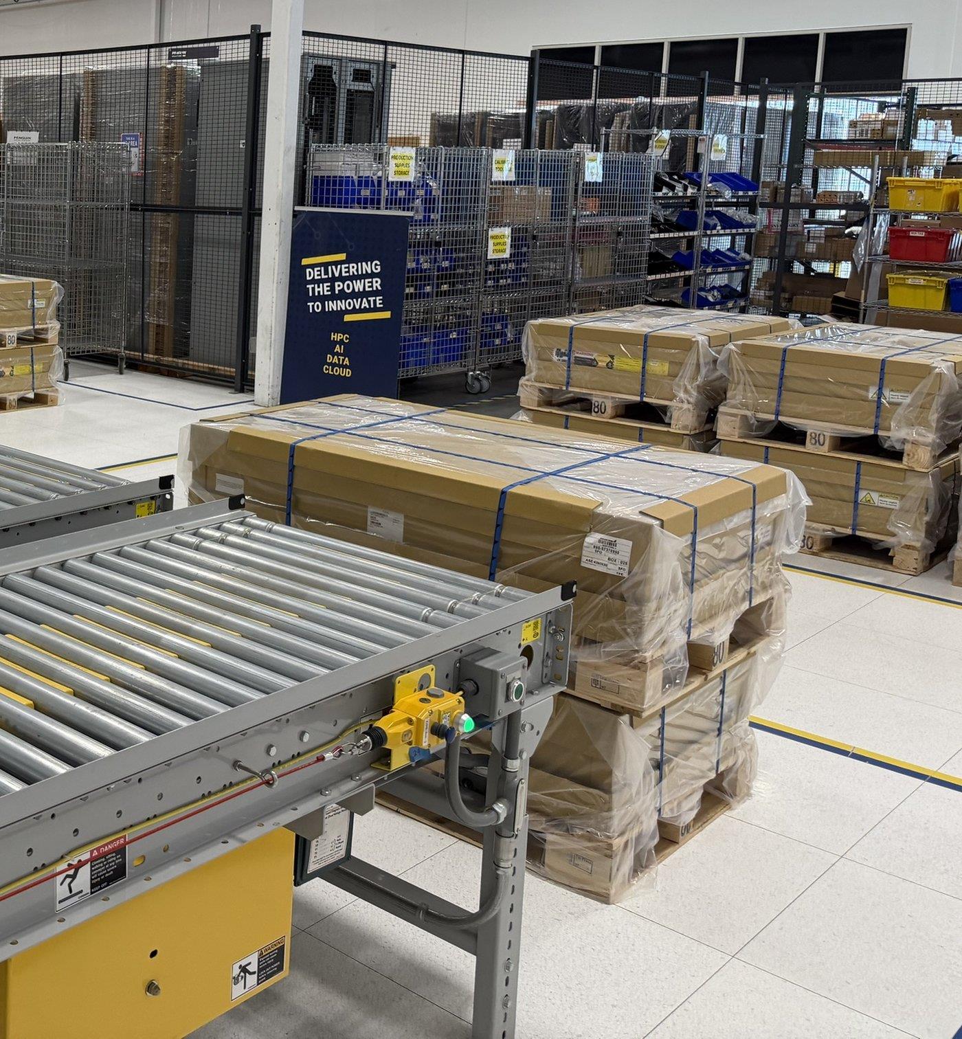 Kit staging area with crated pallets, caged storage and conveyors
